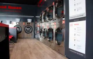 A laundry room featuring a decorative sign that reads Speed Queen, adding a cozy touch to the space.